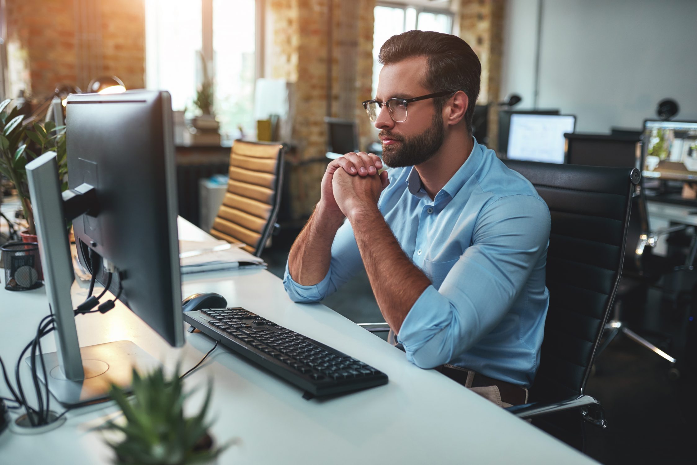Homme qui réfléchit devant son ordinateur